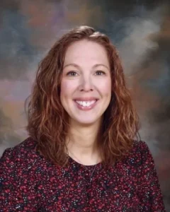 A woman with red hair and a floral shirt.