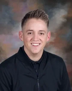 A man in black shirt smiling for the camera.