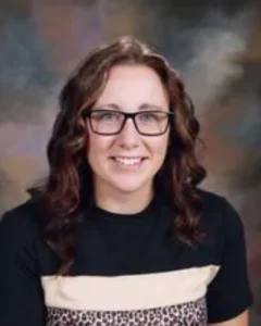 A woman with glasses and long hair wearing a black shirt.